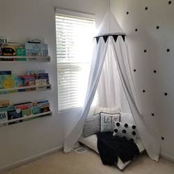 Reviewer's photo showing the white canvas canopy reading nook in their kid's play space