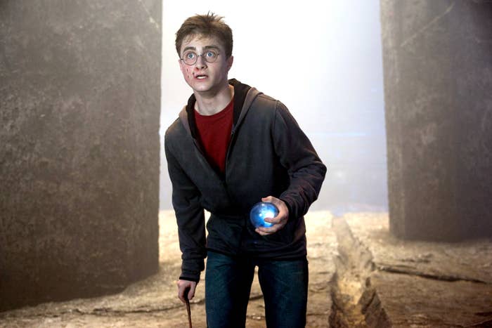 Radcliffe clutches an orb and brandishes his wand at his side as Harry Potter