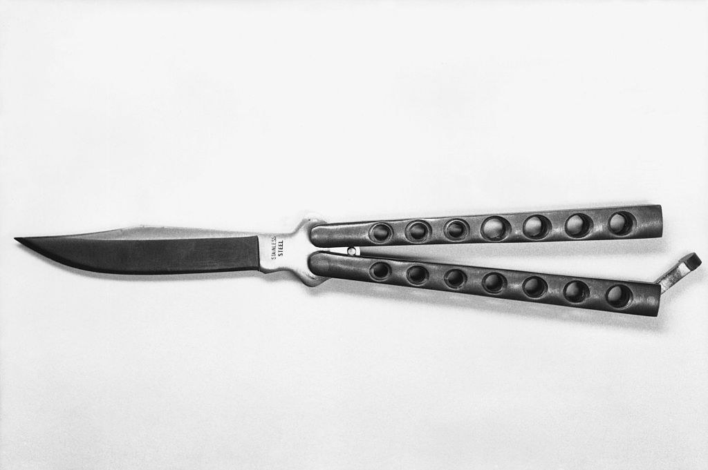 A butterfly knife with its two hinged handles that can conceal the blade