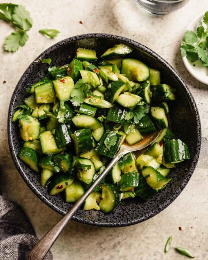 Chopped, smashed cucumber salad in a bowl.