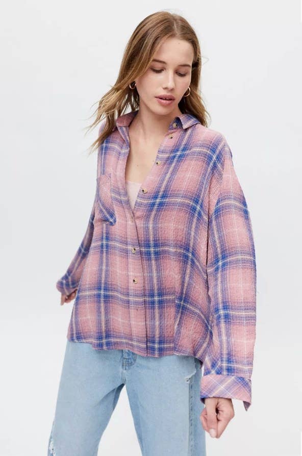 Model wearing pink and blue flannel with light jeans