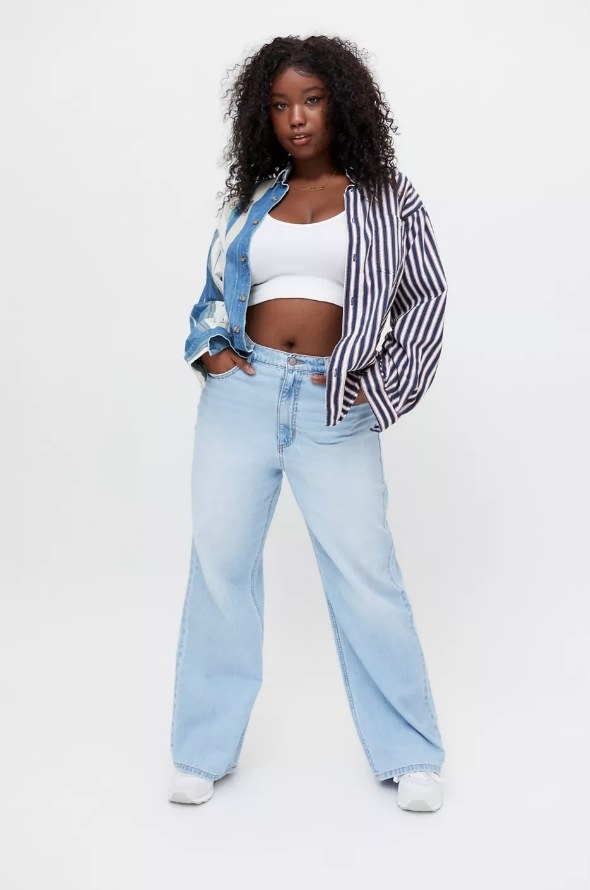 Model wearing light wash wide leg jeans with white crop top and striped cropped jacket
