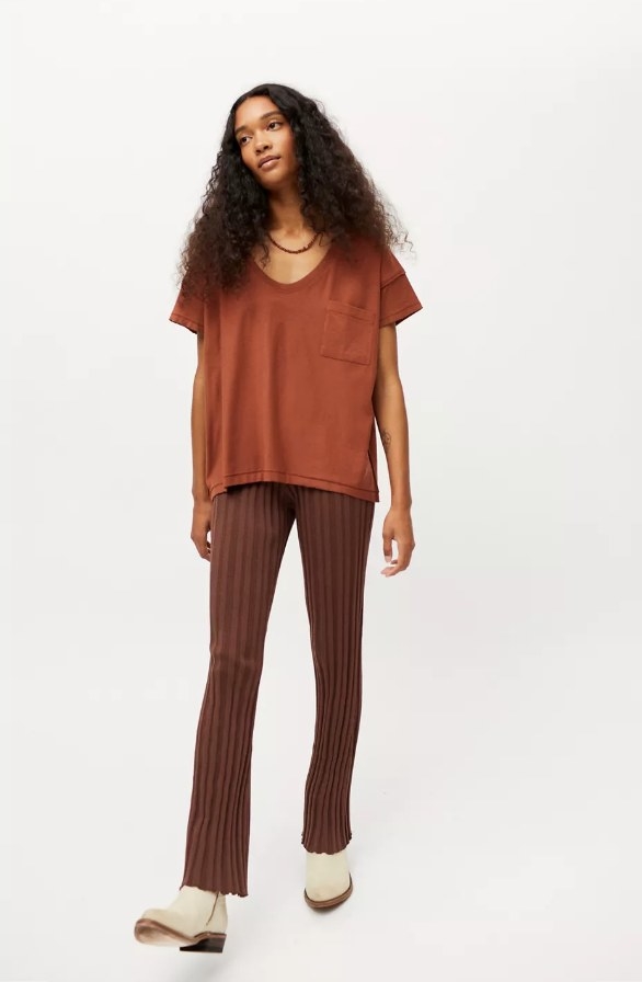 Model wearing burnt orange tee with brown pants