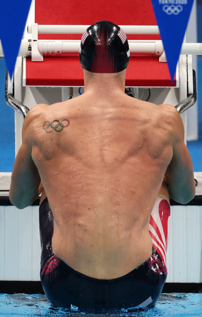 An American swimmer lifts himself out of the water as he prepares to launch for the start of a backstroke race
