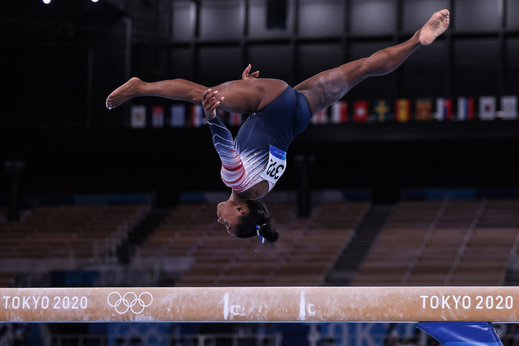Simone upside down as she&#x27;s mid-air over the balance beam