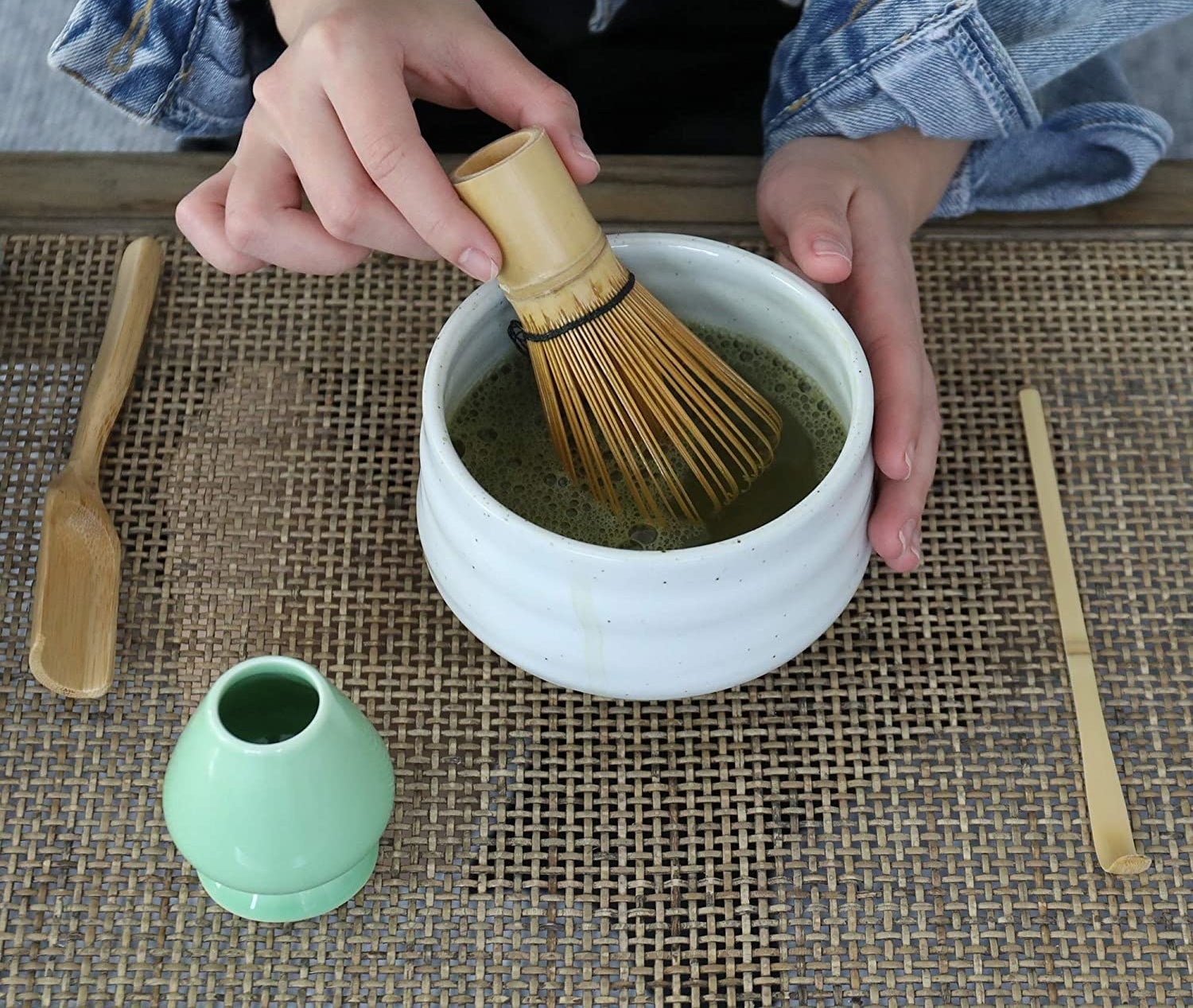model hand using the whisk to whisk matcha