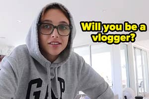 Emma Chamberlain wears a sweatshirt with the hood up while standing in her kitchen