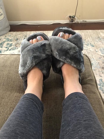 reviewer feet wearing the slippers in gray
