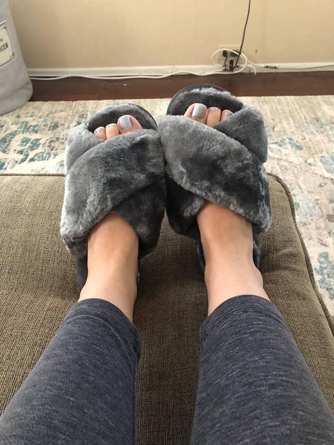 reviewer feet wearing the slippers in gray