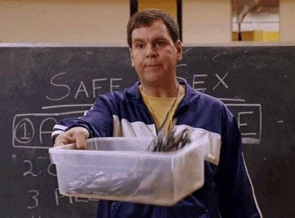 Coach Carr holding out a plastic container filled with condoms