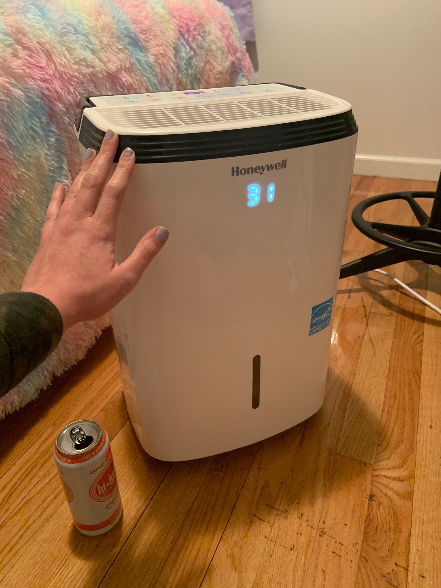 My large dehumidifier with my hand and a can, for scale.