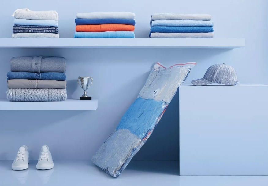 A compression bag filled with clothing lying against a shelf
