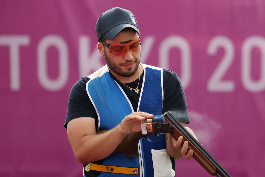 A shooter wearing orange sunglasses while loading his gun