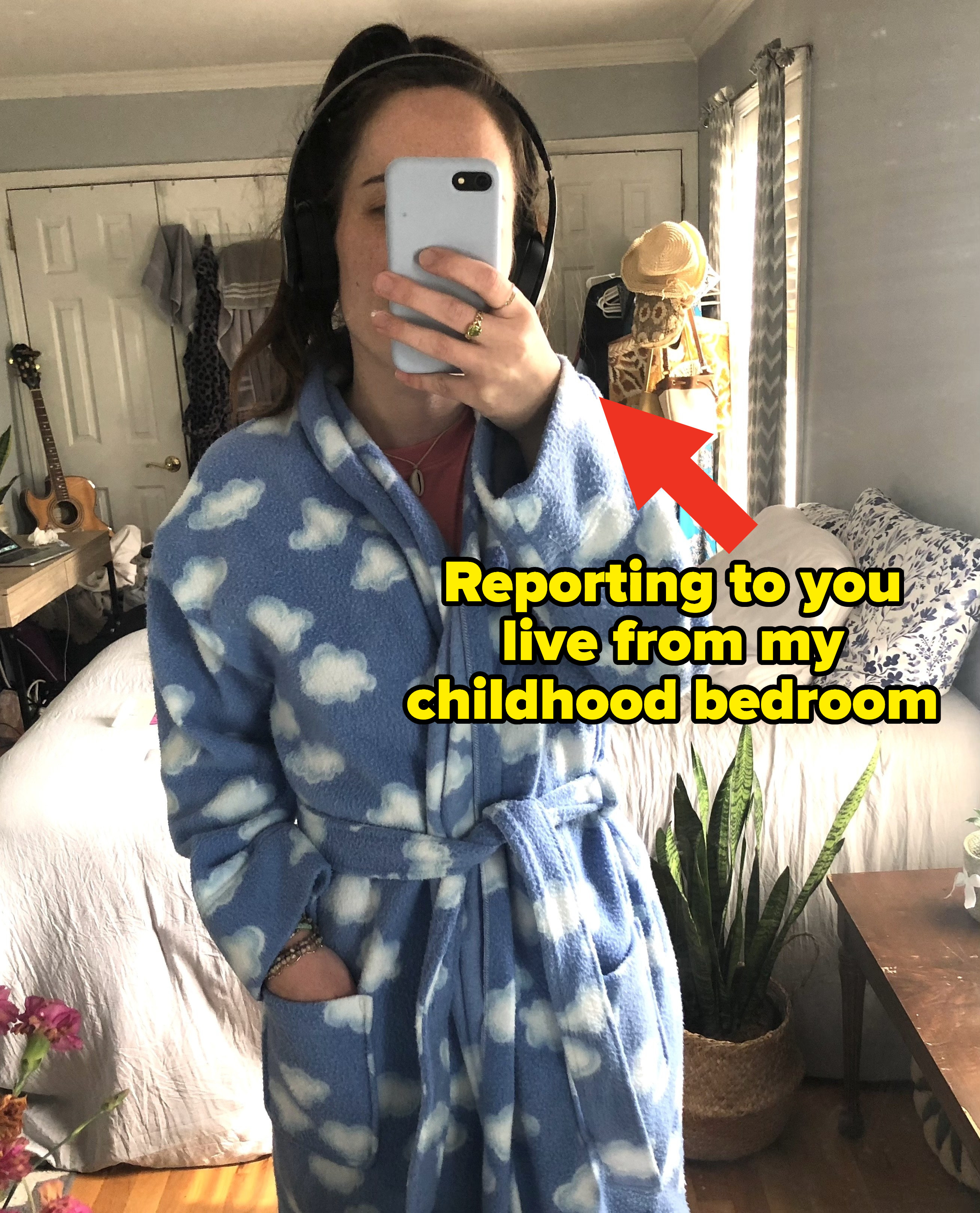 Me taking a mirror selfie in my childhood bedroom, with text on it that reads: &quot;Reporting to you live from my childhood bedroom&quot;