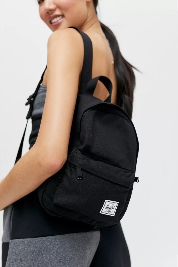Model wearing black Herschel mini backpack