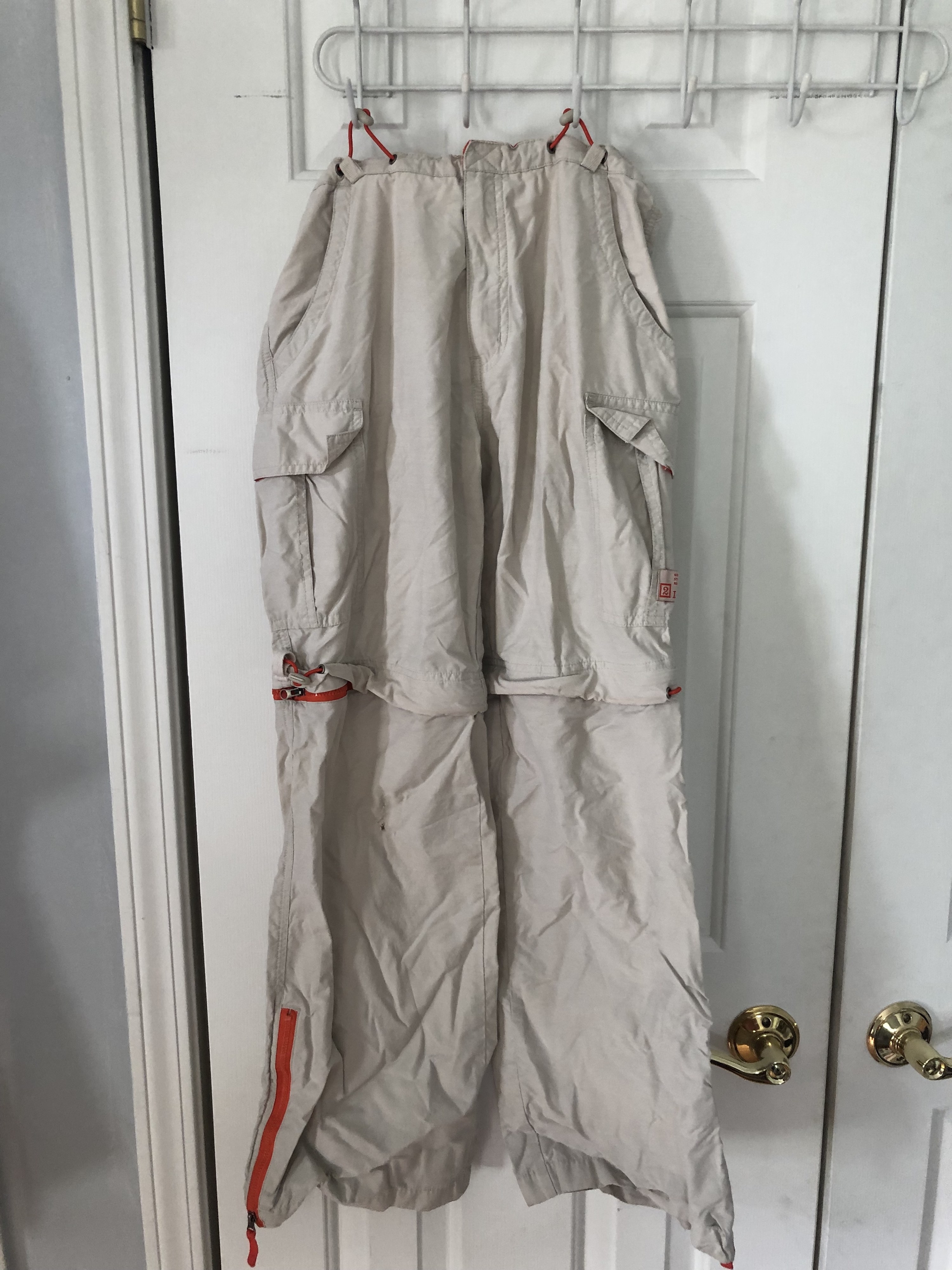 Zip-off pants hanging from a closet door