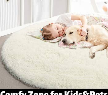 A child and a dog lounging on the white round shag rug