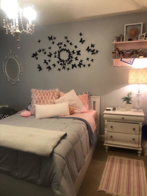 Reviewer's photo showing the black butterfly stickers on a bedroom wall