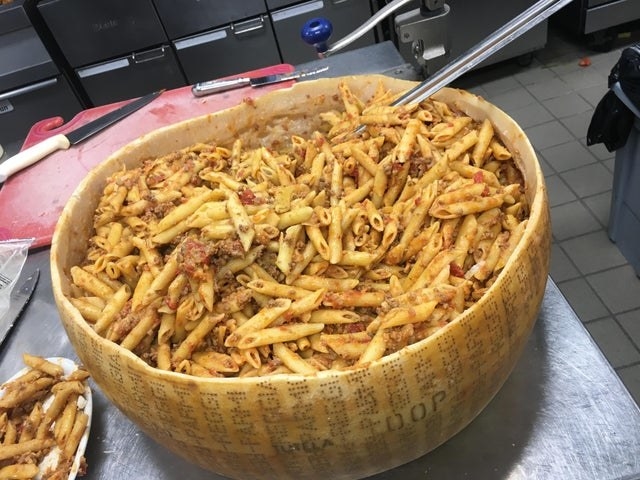 A wheel of Parmesan with pasta