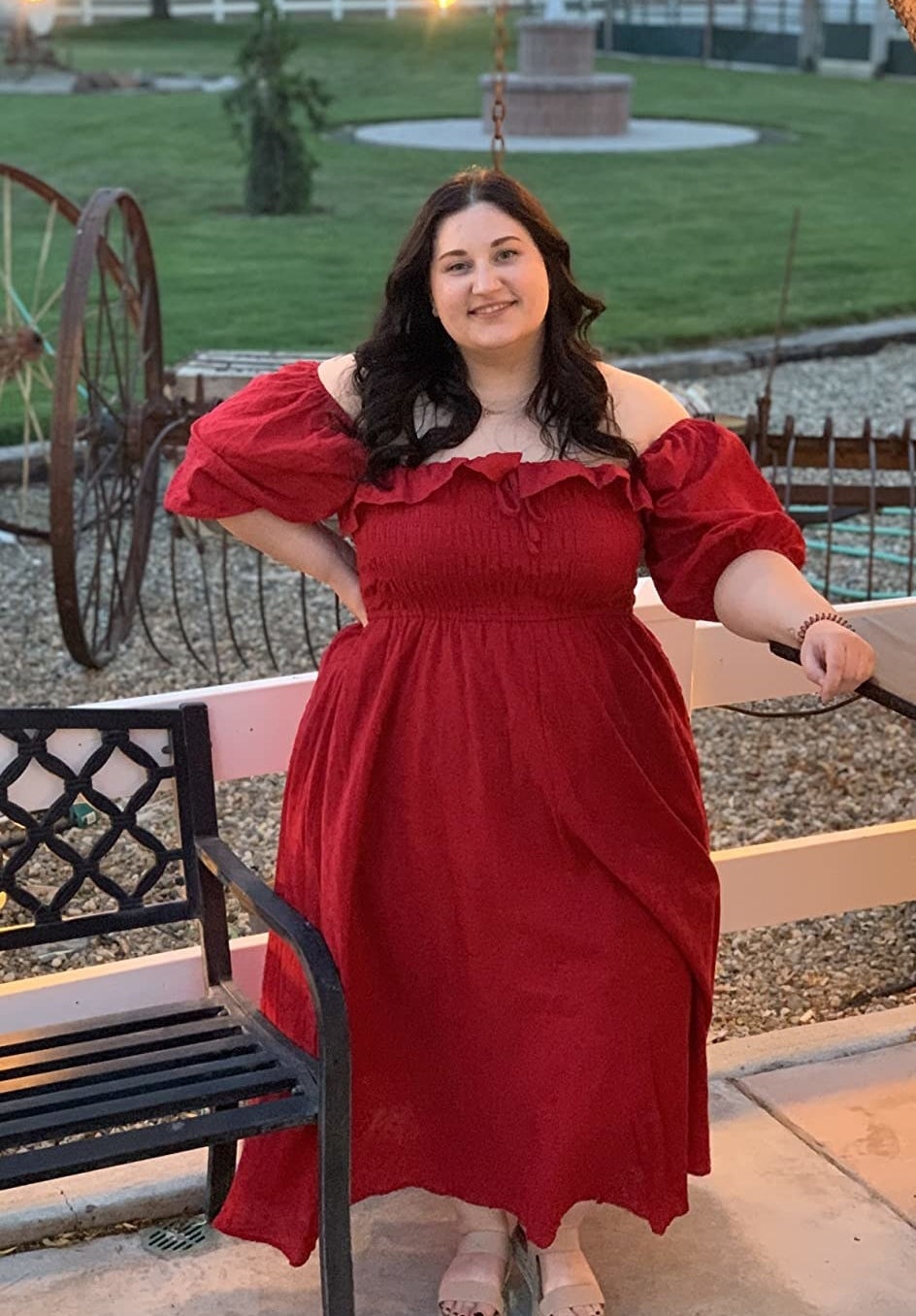 A reviewer wears the dress in red