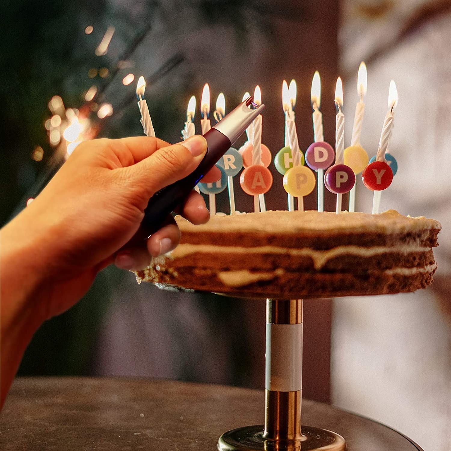 A person lighting birthday cake candles with the lighter