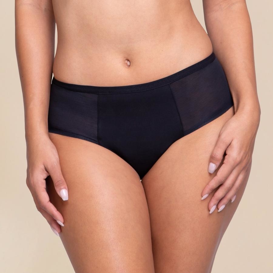 model wearing black underwear with mesh panels on the sides