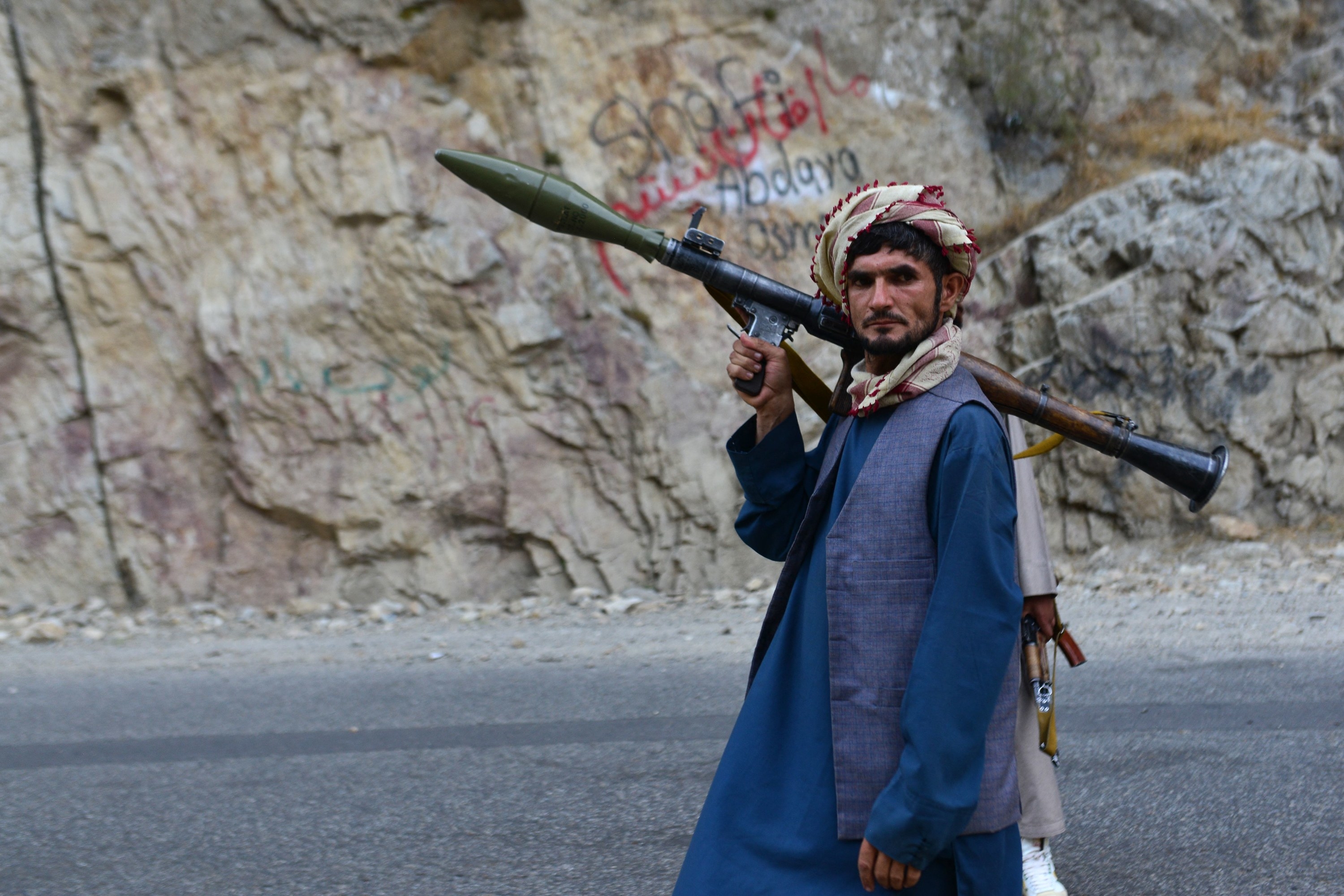 An Afghan soldier holds a gun as he patrols a remote road