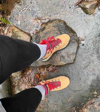 reviewer wears tan boots while hiking on trail