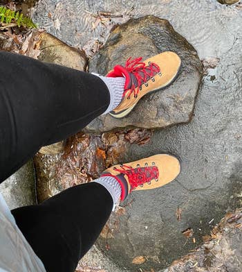 reviewer wears tan boots while hiking on trail