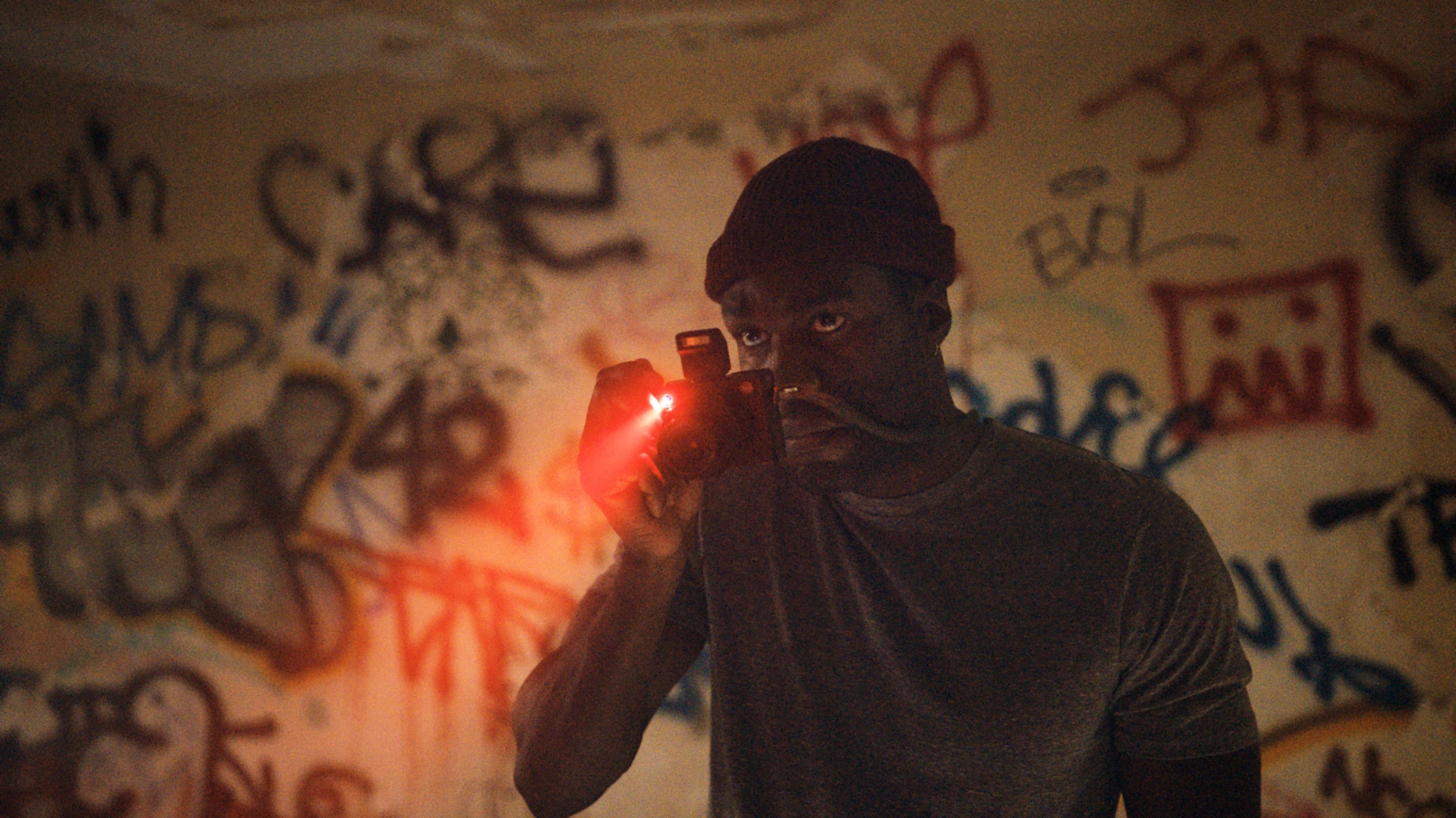 Yahya Abdul-Mateen holding a camera in a scene from Candyman