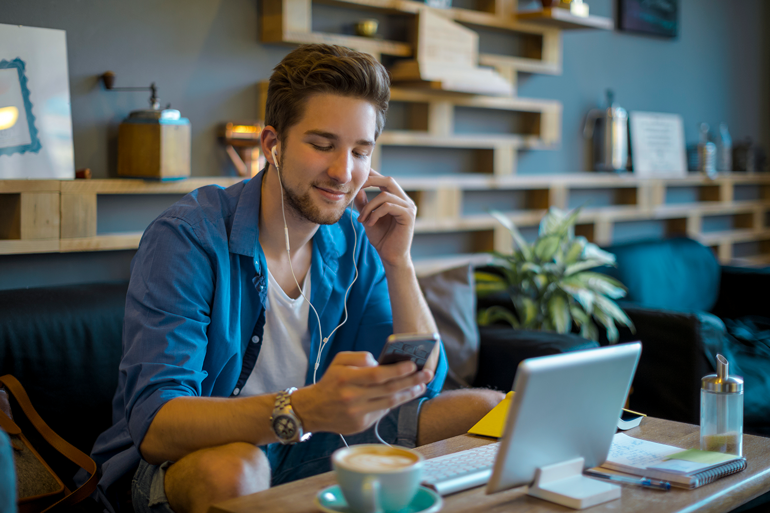 A young man on the phone while in front of his computer