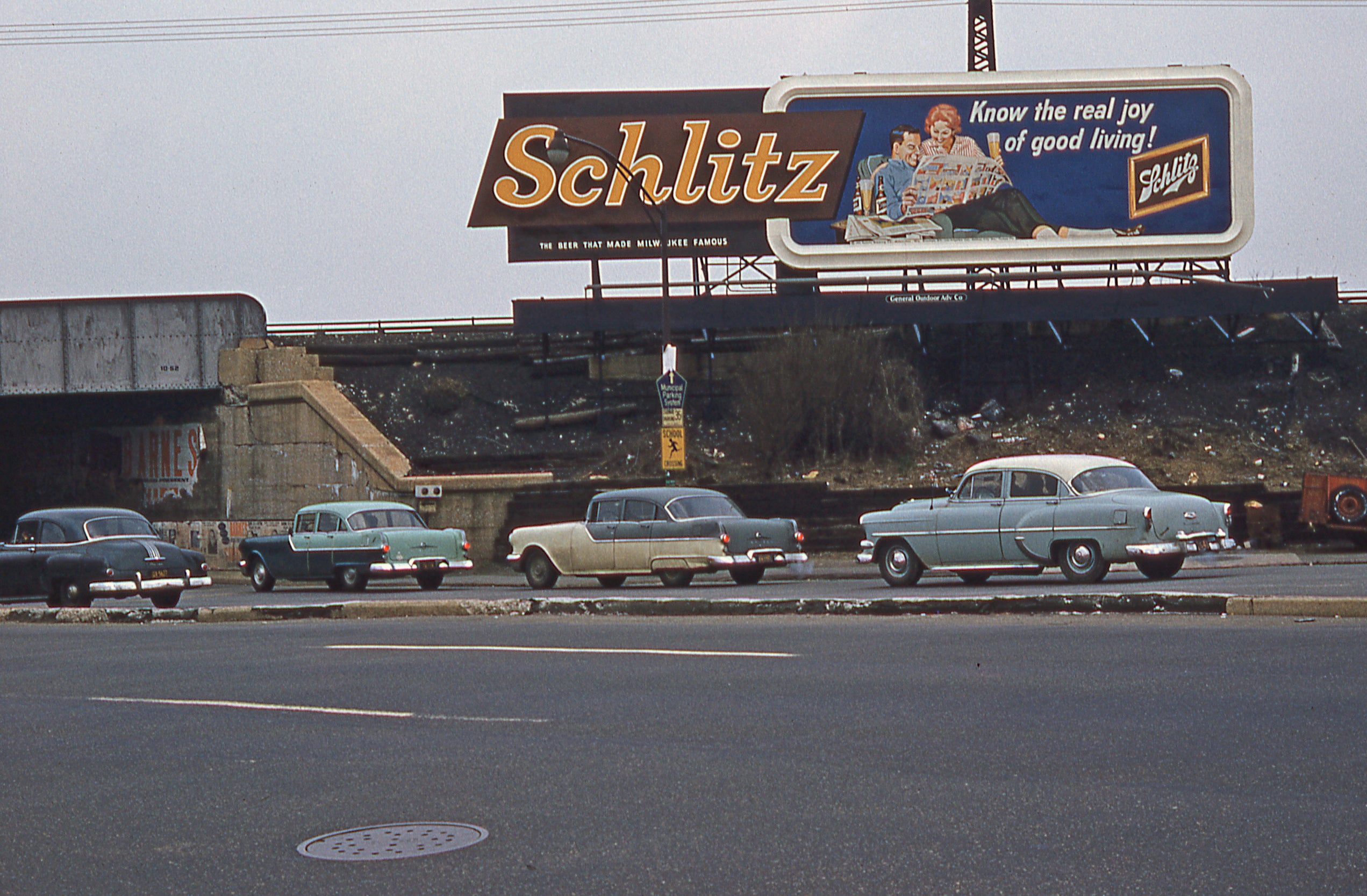A Schlitz billboard sign above a highway in the 70s