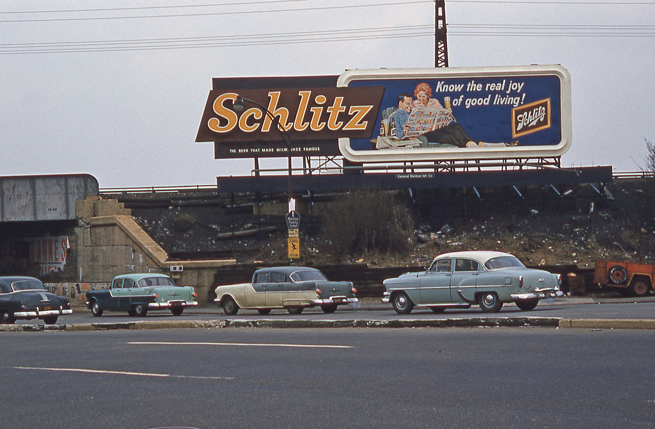 A Schlitz billboard sign above a highway in the 70s