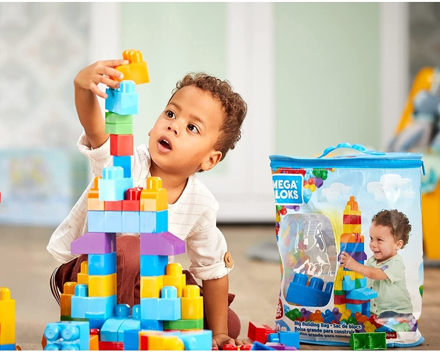 A child playing with the the jumbo blocks with a storage bag nearby