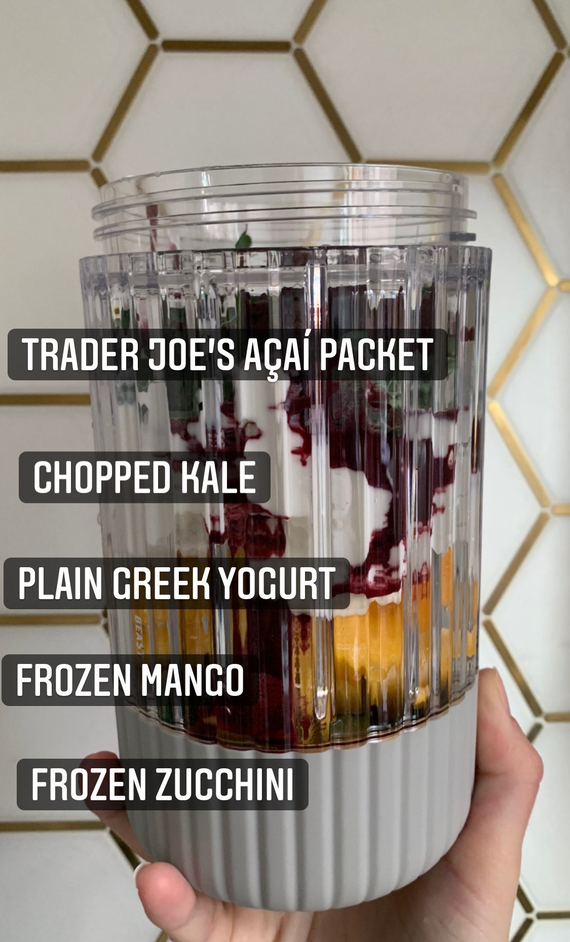 My blending jar with the following ingredients: frozen zucchini and mango, plain greek yogurt, chopped kale, and a Trader Joe&#x27;s acai packet