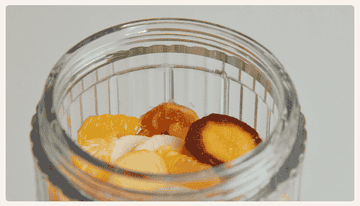 A gif of a model twisting the blade base onto the jar full of ingredients