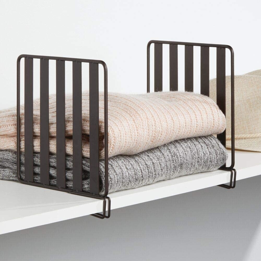 A shelf divider containing two neatly folded sweaters