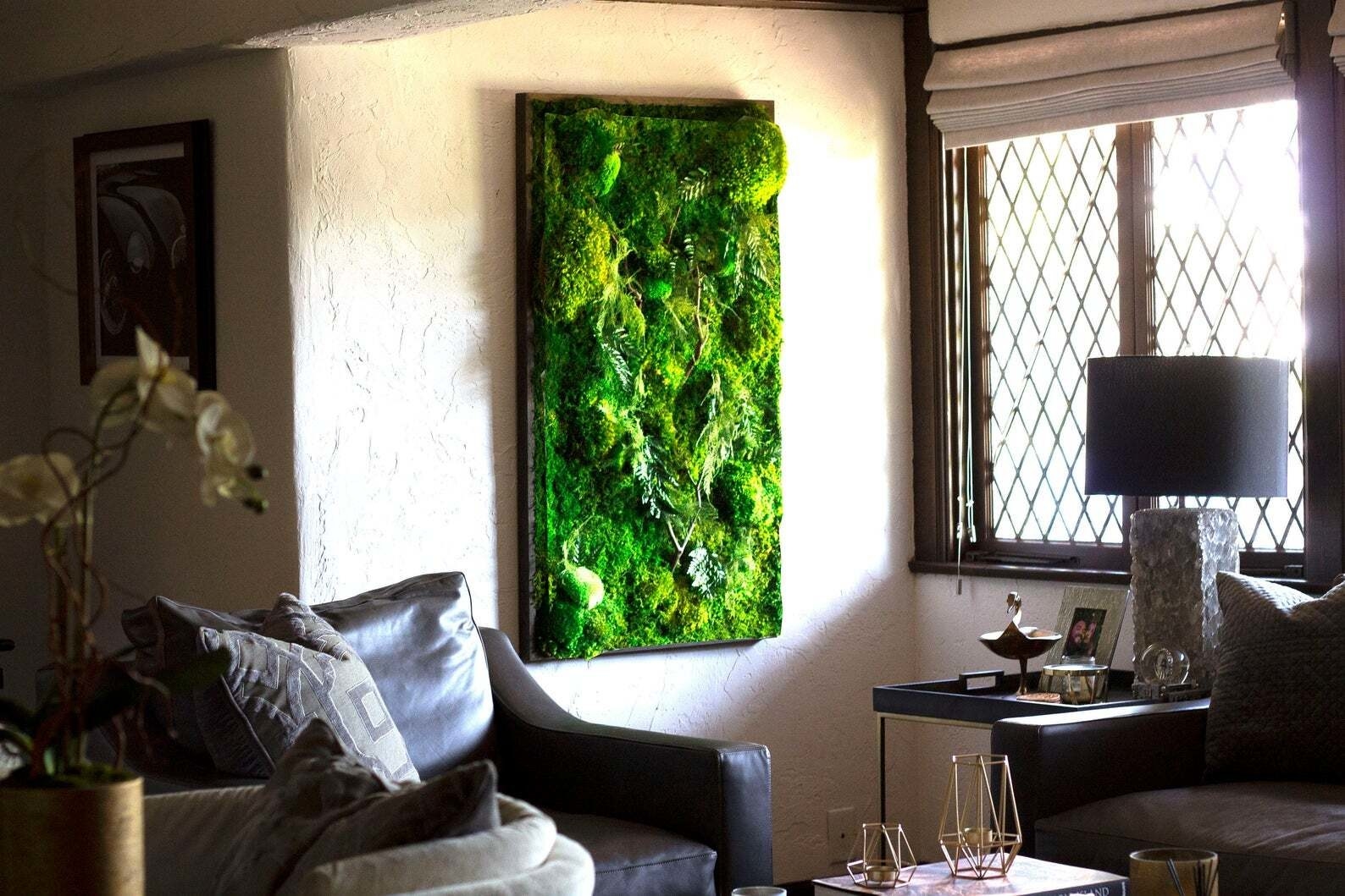 cottage living room with large moss art piece on a wall beside a window