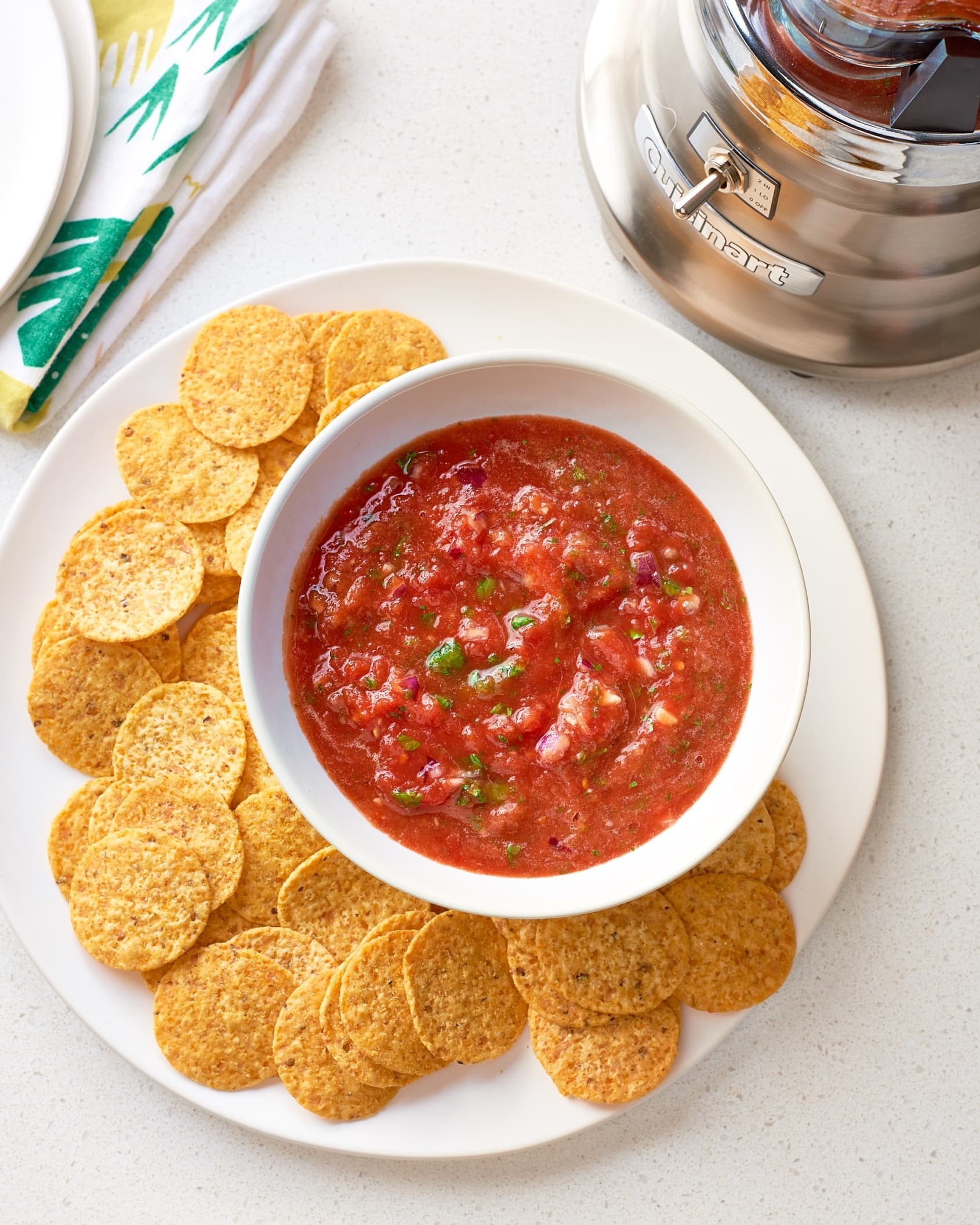 The salsa in a bowl next to a blender