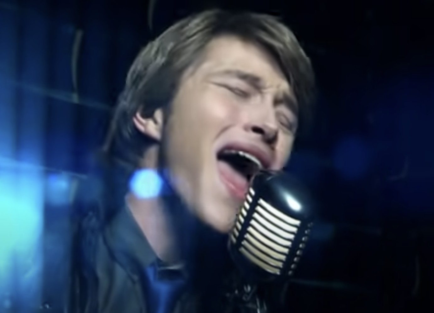 Sterling Knight is singing into a mic