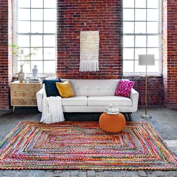 braided colorful rug in a loft-style room with exposed brick and concrete floors