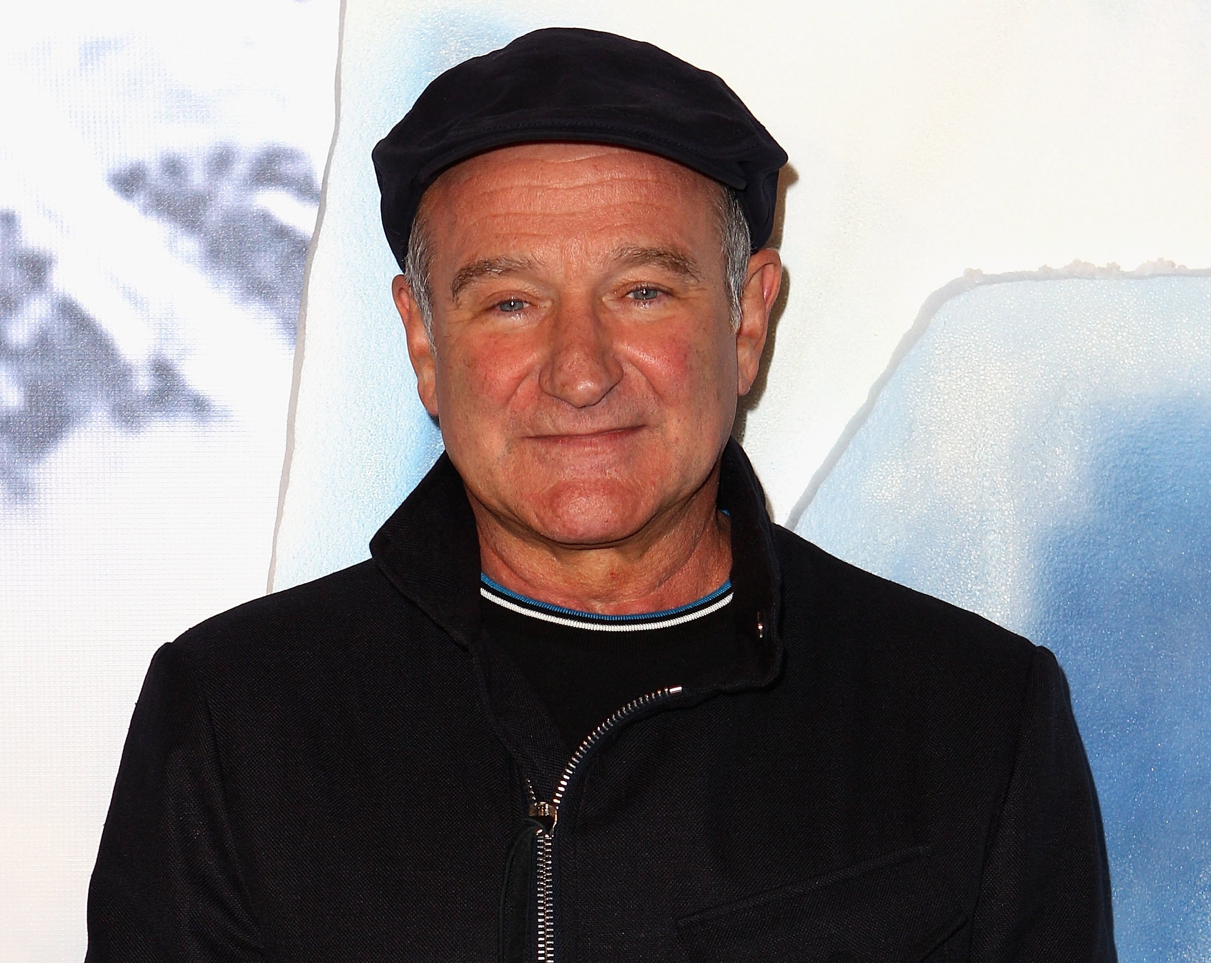 Robin smiles while wearing a newspaper cap and jacket to an event
