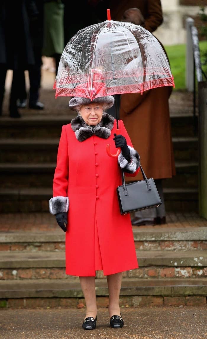 queen Elizabeth looking kinda awkward while holding an umbrella