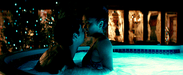 Peter K pulling Lara Jean into his lap in the hot tub
