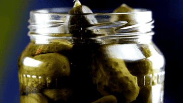 Close up GIF of someone taking a pickle from a jar.