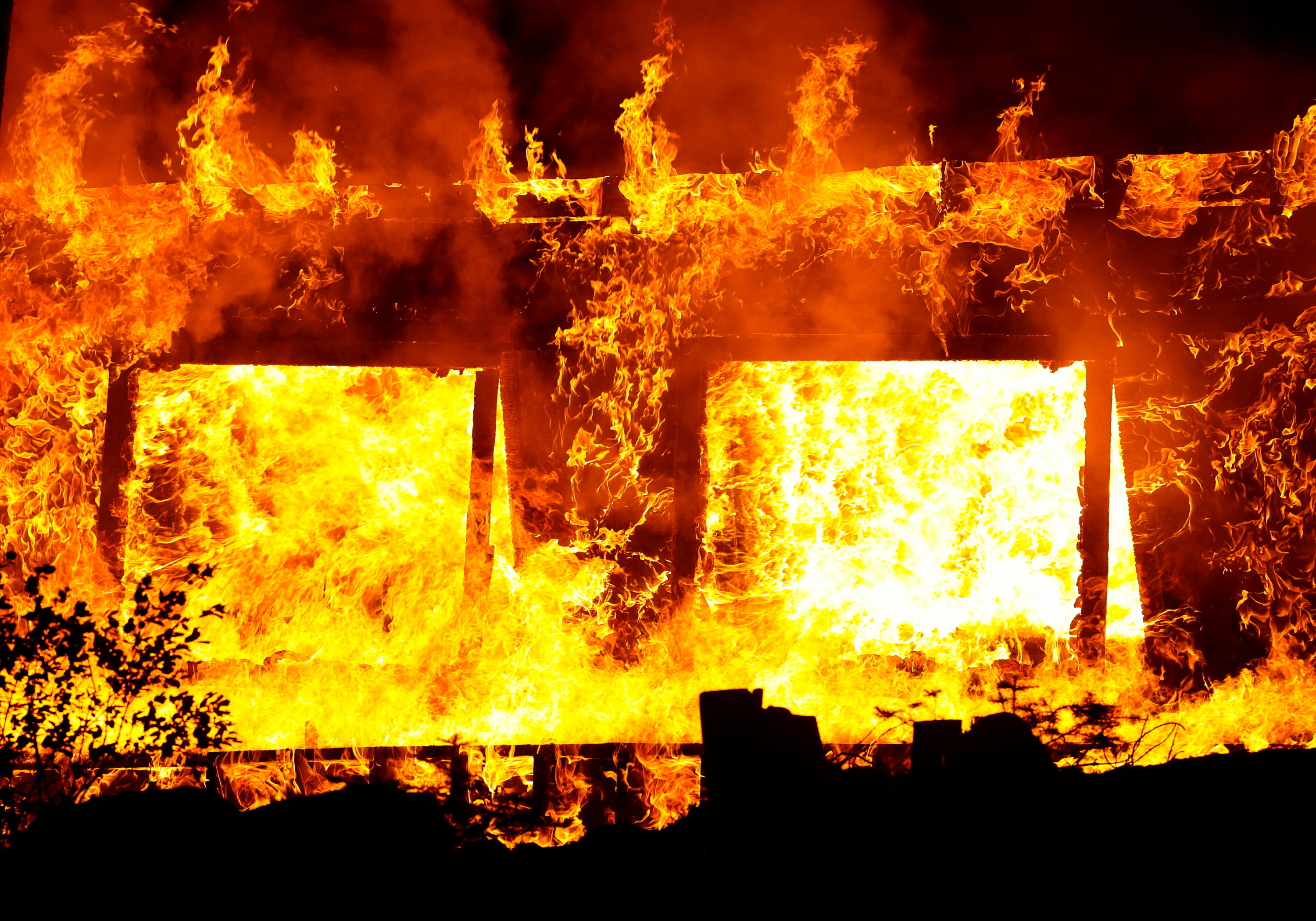 Flames violently destroy a structure