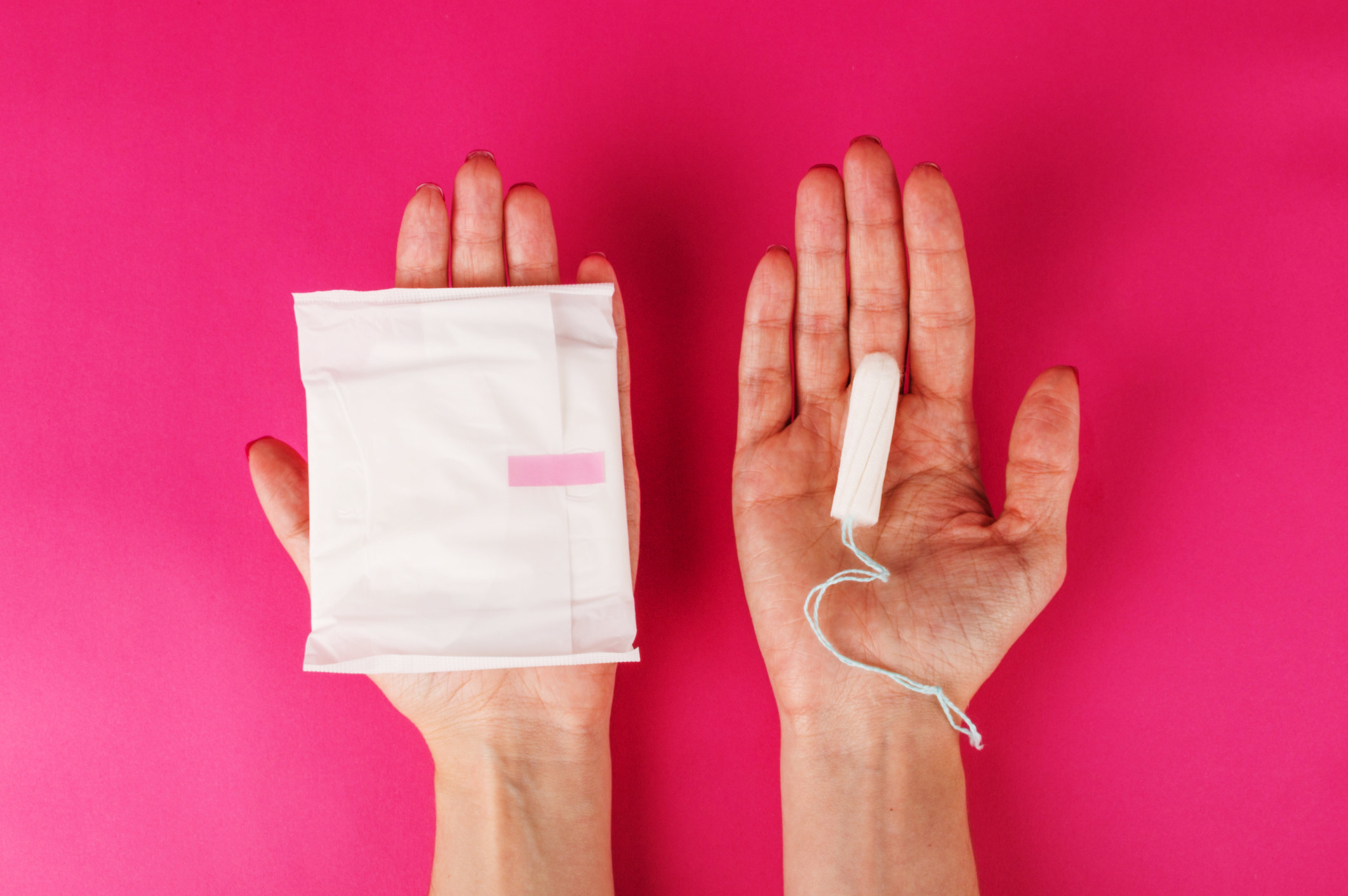 Someone holding a pad in one hand and a tampon in the other