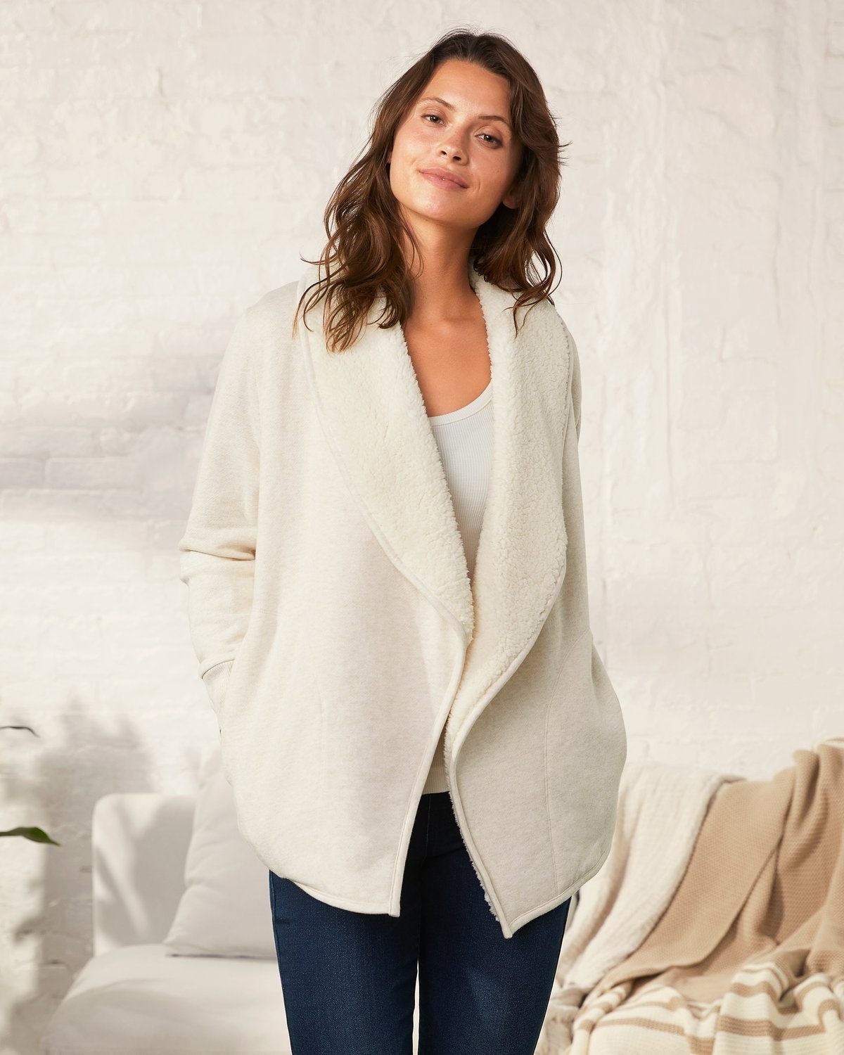 a model in a white sherpa-lined cardigan