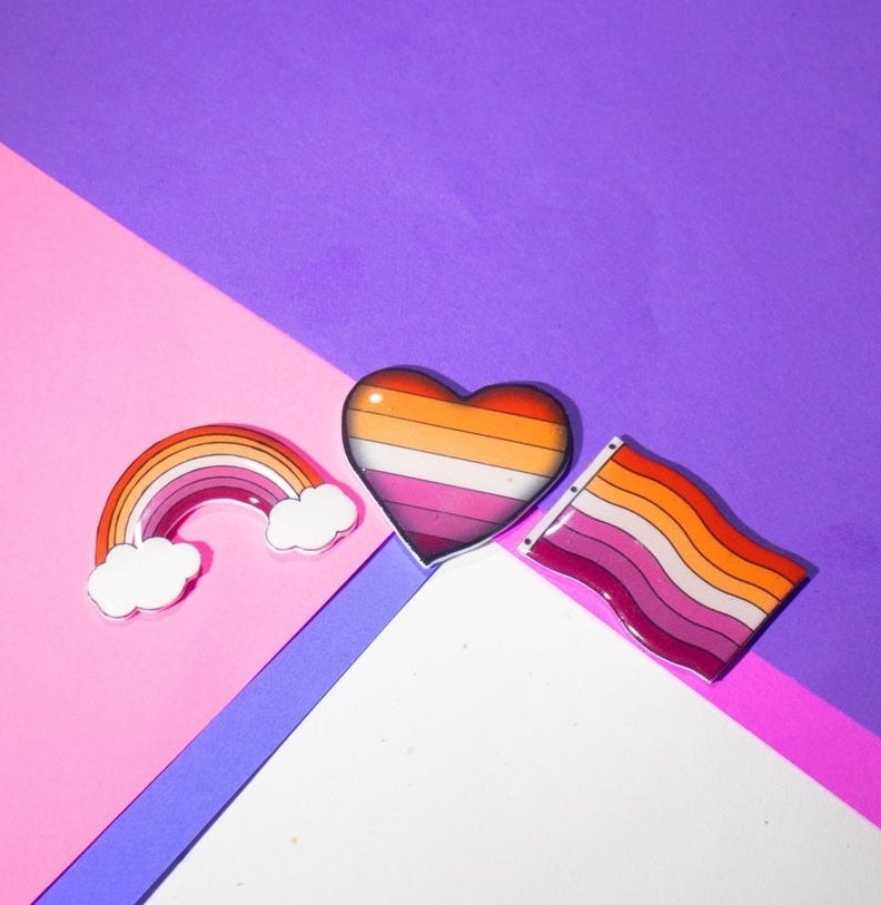 rainbow, heart, and flag pins with the lesbian pride colors
