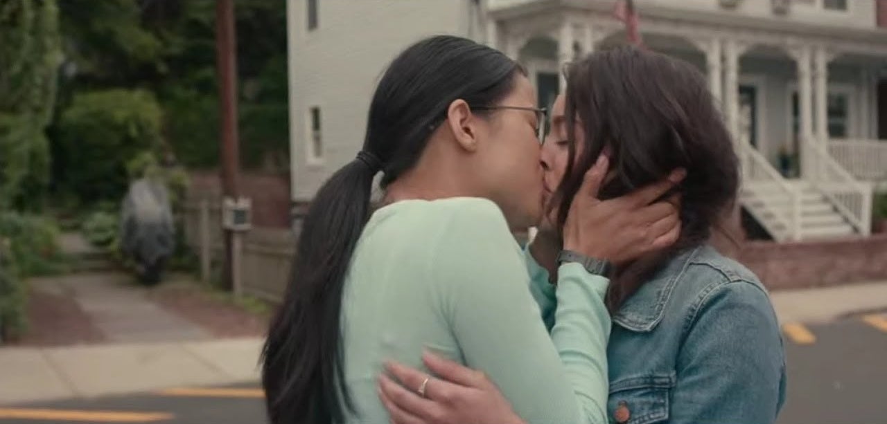 Ellie kissing Aster outside on the street